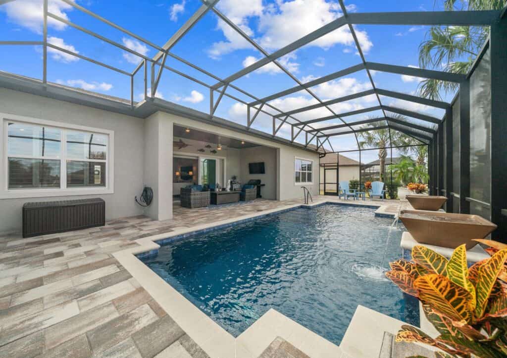real estate photo of a screened in pool and patio